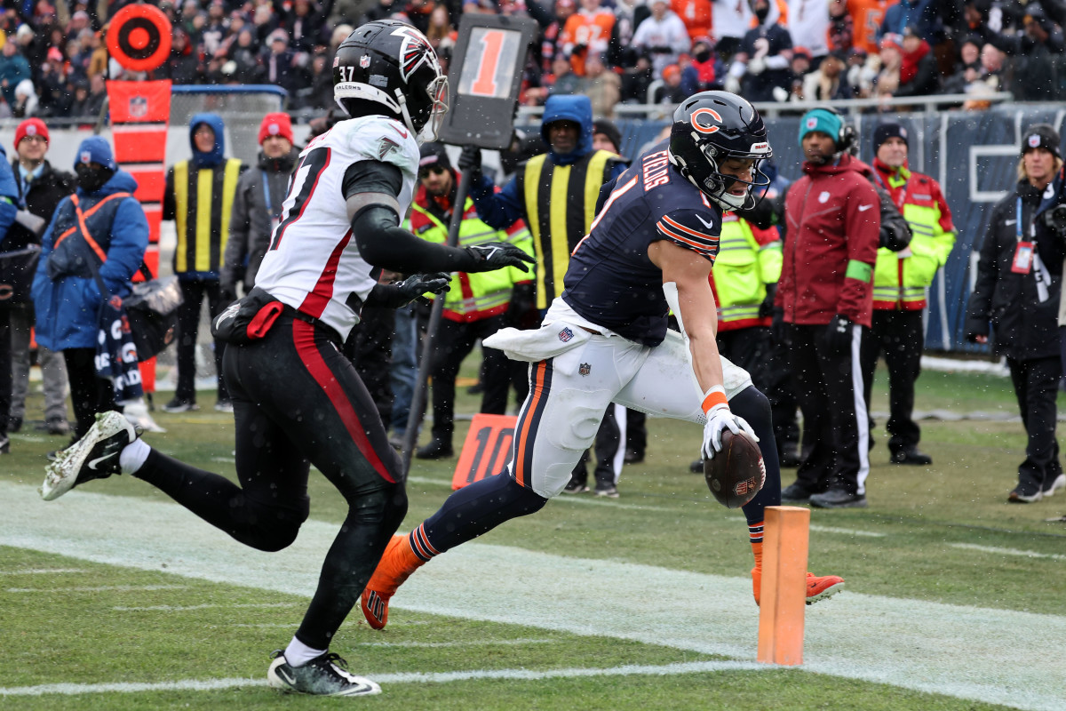 Dec 31, 2023; Chicago, Illinois, USA; Chicago Bears quarterback Justin Fields (1) rushes for a touchdown against the Atlanta Falcons during the first half at Soldier Field. 